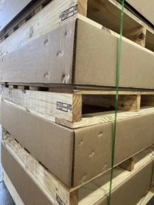 Corner angle of stacked corrugated shipping containers mounted between wooden pallets